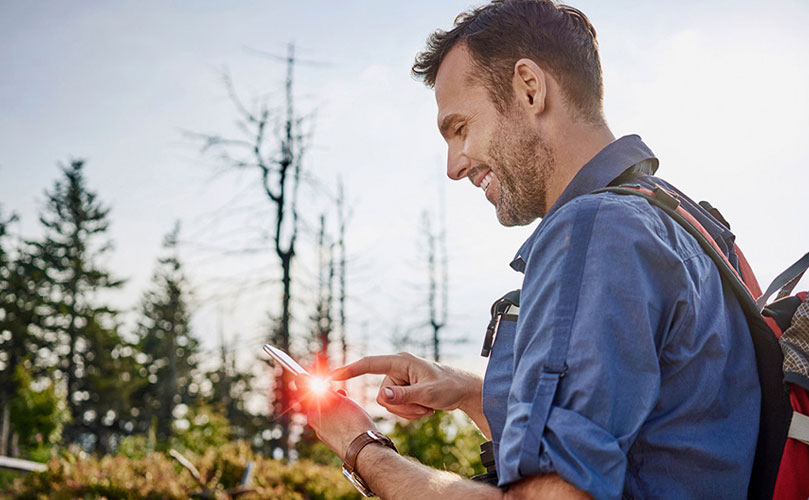 Mujer con una bolsa de compras en la mano revisando su teléfono