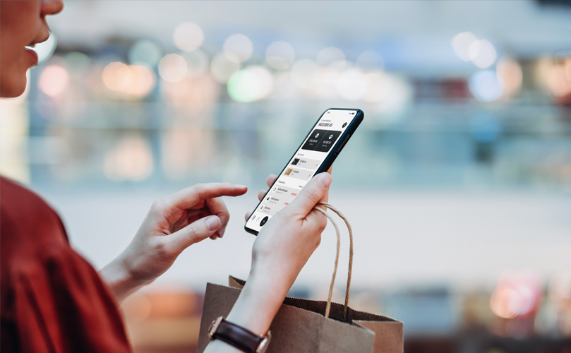 手拿購物袋的女人在檢查手機