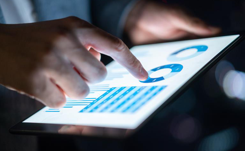 Hand pointing at charts on a tablet